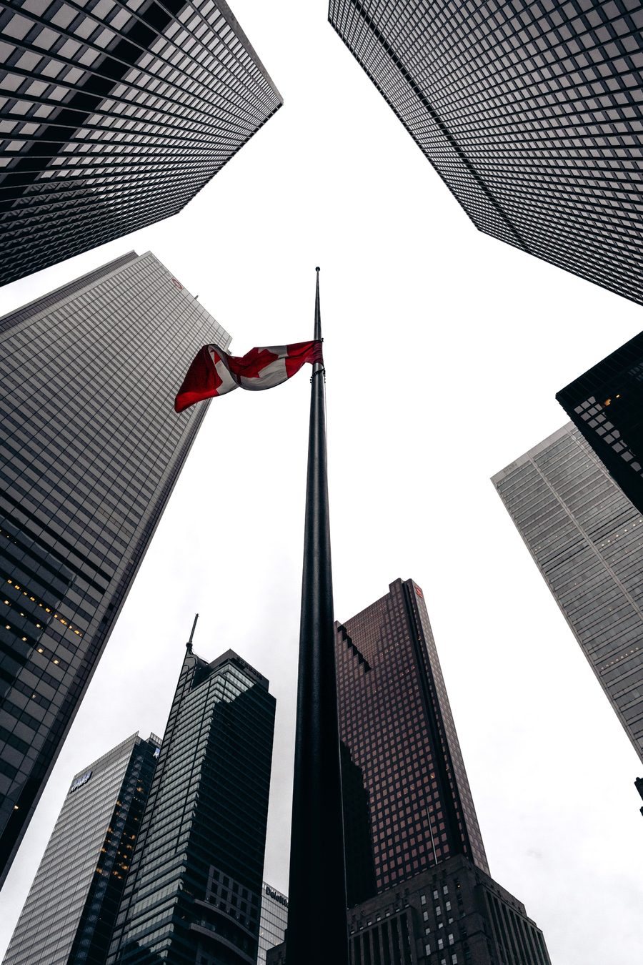 Canadian flag flying among downtown skyscrapers